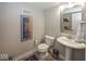 A simple bathroom with a toilet, pedestal sink, and auto racing themed wall art at 13301 Minden Dr, Fishers, IN 46037