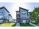 Modern townhomes feature brick and metal siding, landscaped lawns and entryways with concrete steps at 13301 Minden Dr, Fishers, IN 46037
