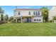 Expansive backyard featuring a covered patio with ceiling fan, lush green lawn, and charming outdoor seating at 14052 Rayners Ln, Fishers, IN 46037