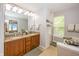 Bright bathroom featuring double vanity with granite counters, soaking tub, and tiled shower at 14052 Rayners Ln, Fishers, IN 46037