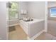 Bathroom featuring a large soaking tub next to a window providing natural light at 14052 Rayners Ln, Fishers, IN 46037
