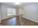 Bright living room features wood-look flooring, a large window, and neutral walls at 14052 Rayners Ln, Fishers, IN 46037