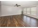 Open living room featuring large windows for natural light, a ceiling fan and wood-look flooring at 14052 Rayners Ln, Fishers, IN 46037