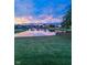 Beautiful pond view with fountain at sunset; spacious lawn and fence in foreground at 14052 Rayners Ln, Fishers, IN 46037
