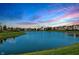 Picturesque view of a tranquil pond reflecting a vibrant sunset, surrounded by lush greenery and neighborhood homes at 14052 Rayners Ln, Fishers, IN 46037
