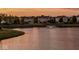 Scenic sunset view of a pond with fountain and suburban homes in the background at 14052 Rayners Ln, Fishers, IN 46037