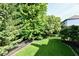 View of a backyard with manicured lawn, a fence and lush landscaping, creating a serene and private outdoor space at 14082 Brazos Dr, Carmel, IN 46033