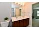 Bright bathroom featuring a double sink vanity with wood cabinets and a large mirror with vanity lighting at 14082 Brazos Dr, Carmel, IN 46033