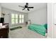 Cozy bedroom with a ceiling fan, neutral walls, a shuttered window, and a small bed with a green blanket at 14082 Brazos Dr, Carmel, IN 46033