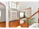 Grand foyer with soaring ceilings, hardwood floors, staircase and elegant light fixture creating a welcoming ambiance at 14082 Brazos Dr, Carmel, IN 46033