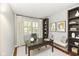 Bright home office with a large desk, custom built-ins, modern decor, and a shuttered window at 14082 Brazos Dr, Carmel, IN 46033