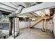 Basement with exposed brick, wood support stairs and concrete floors offering potential for storage or renovation at 1430 W 14Th St, Anderson, IN 46016