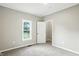 A bedroom with gray walls and gray carpet contains a window and a single door at 1430 W 14Th St, Anderson, IN 46016