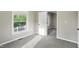 Neutral bedroom with window view to the outside and door to another room with wood floors at 1430 W 14Th St, Anderson, IN 46016