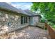 A brick house with a wooden deck featuring a bench swing and lush green trees at 1456 Bent Tree Pl, Greenwood, IN 46143