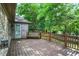 Back Deck featuring a bench swing, surrounded by lush greenery and a brown wooden fence at 1456 Bent Tree Pl, Greenwood, IN 46143