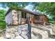 Backyard featuring a brick house, wooden deck, stone steps, and lush green landscaping at 1456 Bent Tree Pl, Greenwood, IN 46143