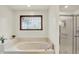 Bathroom featuring a glass shower, soaking tub, and window providing natural light at 1456 Bent Tree Pl, Greenwood, IN 46143