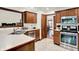 Kitchen features tiled floors, stainless steel appliances, and warm wood cabinetry at 1456 Bent Tree Pl, Greenwood, IN 46143