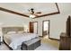 Spacious main bedroom featuring a tray ceiling, ceiling fan, and ensuite bathroom entrance at 1456 Bent Tree Pl, Greenwood, IN 46143