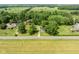 Aerial view of a property featuring green lawns and mature trees near a paved road at 16000 W 700 S, Anderson, IN 46017