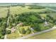 Aerial view of properties with mature trees, a pool, and expansive lawns in a serene countryside setting at 16000 W 700 S, Anderson, IN 46017