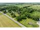 Scenic aerial view of a property with mature trees and surrounding fields, marked by a location pin at 16000 W 700 S, Anderson, IN 46017