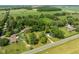 Expansive aerial view of a property with a pool, mature trees, and a well-maintained lawn at 16000 W 700 S, Anderson, IN 46017