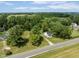 Aerial view of a quaint white home surrounded by mature trees and a vast, lush green lawn at 16000 W 700 S, Anderson, IN 46017