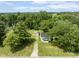Aerial view of a charming home with a detached garage, surrounded by lush greenery and mature trees at 16000 W 700 S, Anderson, IN 46017