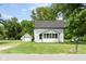 Charming white home featuring a sunroom, set on a well-manicured lawn with an adjacent garage at 16000 W 700 S, Anderson, IN 46017