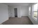 A well-lit bedroom with neutral carpet, white walls, and a large window offering natural light at 17110 Cowbell Dr, Noblesville, IN 46060