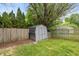 Backyard featuring a gray shed, green grass, trees, and full wooden fencing at 19522 Diamond Way, Noblesville, IN 46062