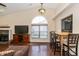 Open-concept living room with vaulted ceilings, a brick fireplace, and wood-look tile floors at 19522 Diamond Way, Noblesville, IN 46062