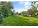 Lush backyard showcases verdant lawn, mature trees, and well-kept landscaping enhancing the home's appeal at 2402 Redspire Blvd, Goshen, IN 46526