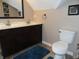 Bathroom featuring a double sink vanity, toilet, mirror, and decor at 2502 N Harding St, Indianapolis, IN 46208