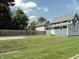 Landscaped yard with a well-kept lawn surrounding a charming home, complemented by a wooden fence at 2502 N Harding St, Indianapolis, IN 46208