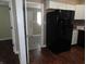 This kitchen features black appliances, white cabinets, and wood-look flooring at 2502 N Harding St, Indianapolis, IN 46208