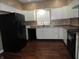 Well-lit kitchen with white cabinets, black appliances, and modern sink at 2502 N Harding St, Indianapolis, IN 46208