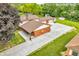 Home showcasing the roof, backyard, multiple garages, and expansive driveway with green lawns at 2823 Tulip Dr, Indianapolis, IN 46227
