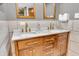 Bathroom showcasing a wooden double vanity with marble countertop and matching framed mirrors at 2823 Tulip Dr, Indianapolis, IN 46227