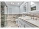 Bathroom featuring a double sink vanity, marble tile, glass enclosed shower, and modern fixtures at 2823 Tulip Dr, Indianapolis, IN 46227
