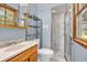 Full bathroom with modern shower, wood vanity, and window offering natural light and outdoor views at 2823 Tulip Dr, Indianapolis, IN 46227