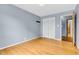 Cozy bedroom featuring hardwood floors, light blue walls, and a closet with white bi-fold doors at 2823 Tulip Dr, Indianapolis, IN 46227