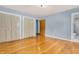 Bright bedroom with hardwood floors, light blue walls, and closet doors leading to the adjacent bathroom at 2823 Tulip Dr, Indianapolis, IN 46227