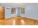 Light-filled bedroom with hardwood floors, two windows with a view, and light blue walls at 2823 Tulip Dr, Indianapolis, IN 46227