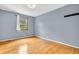 Bedroom with hardwood floors, soft blue walls, and a bright window with serene outdoor views at 2823 Tulip Dr, Indianapolis, IN 46227
