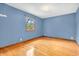 Bright bedroom with hardwood floors, blue walls, and a window with natural light at 2823 Tulip Dr, Indianapolis, IN 46227