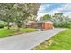 Charming two-story home with a brick exterior, front porch, lush landscaping, and long driveway at 2823 Tulip Dr, Indianapolis, IN 46227
