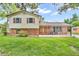 Charming two-story home featuring a well-manicured lawn and a covered front porch with rocking chairs at 2823 Tulip Dr, Indianapolis, IN 46227